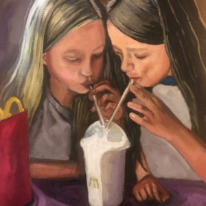 Portrait of two young girls drinking milkshake